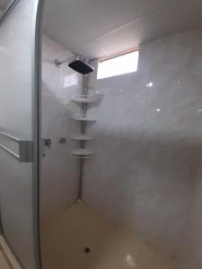 a shower with a shelf in a room at KARIPERU in Mollendo
