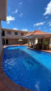 una gran piscina azul frente a un edificio en Hotel Galeria en Santiago de Veraguas