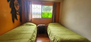 two beds in a small room with a window at Alojamiento La Serena CQ in La Serena