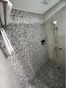 a bathroom with a shower with a tiled floor at Sendale Tainan Science Park Hotel in Xinshi