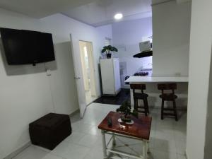 een woonkamer met een tv en een keuken met een tafel bij AYARANA SAN FERNANDO Habitación Cali in Cali