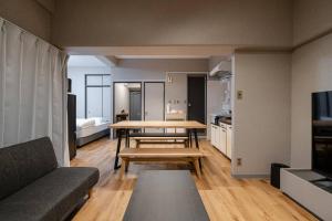a living room with a table and a couch at TasoneUrbanStayOsaka なんば日本橋南不夜城706 in Osaka