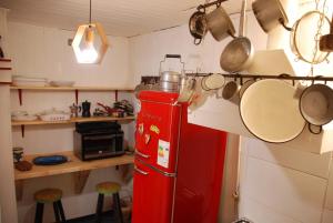 cocina con nevera roja, ollas y sartenes en Hostel Cala 816 en Frutillar