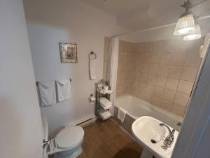 a bathroom with a toilet and a sink and a tub at 302 Suite Confort Urbain in Trois-Rivières