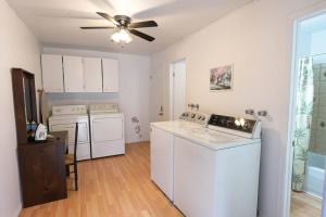 cocina con electrodomésticos blancos y ventilador de techo en 304 Chambre Familiale Spacieuse, en Trois-Rivières