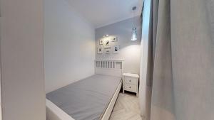 ein kleines Schlafzimmer mit einem Bett und einem Vorhang in der Unterkunft Lillu Apartament 2 in Bydgoszcz