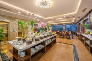 ein Buffet in einem Restaurant mit Tischen und Stühlen in der Unterkunft Golden Lotus Hotel Da Nang in Đà Nẵng