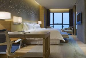 een slaapkamer met een groot bed, een bureau en een bureau bij The Westin Chongqing Liberation Square in Chongqing