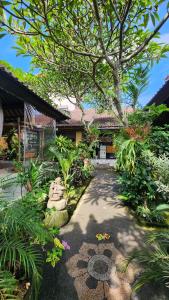 a garden with a tree in the middle of a building at Bale Bali House in Ubud