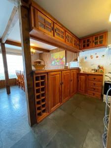 a large kitchen with wooden cabinets and a table at Casa Lican Ray in Licán Ray