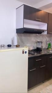 a kitchen with a stove and a white refrigerator at Apartamentos en el Norte de cali in Cali