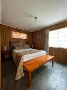李肯雷的住宿－Casa Lican Ray，一间卧室配有一张床和长凳