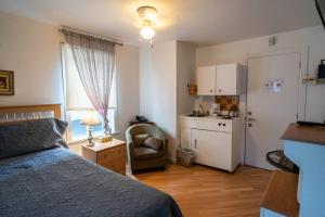ein kleines Schlafzimmer mit einem Bett und einer Küche in der Unterkunft 307 Chambre Double pour Travailleurs in Trois-Rivières