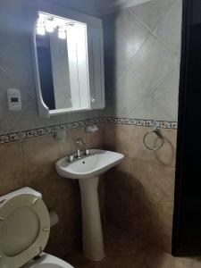 Un baño con inodoro, lavabo y espejo. en La Margarita, en Federación 8 fotos más
