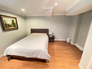 - une chambre avec un lit et du parquet dans l'établissement Arbutus violet room, à Vancouver