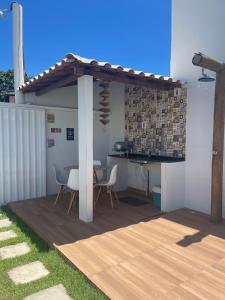 a patio with a table and chairs under a pergola at Casa de praia Jauá in Camaçari