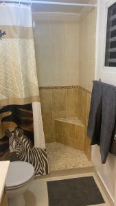 a bathroom with a shower with a zebra on the floor at Magnifique aux Caraibes residence Tradewinds in Cupecoy