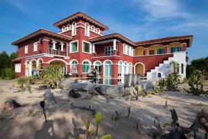 湄平的住宿－Hacienda Resort - Mae Phim，一座大红房子,位于长满树木的沙滩上