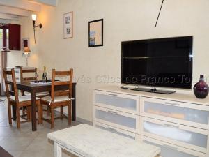 ein Wohnzimmer mit einem großen TV und einem Esstisch in der Unterkunft Gîte Montlouis-sur-Loire, 2 pièces, 2 personnes - FR-1-381-488 in Montlouis-sur-Loire