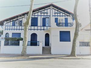 biało-niebieski dom z dwoma drzewami w obiekcie Appartement cosy 4 pers, proche plage et commerces, Capbreton - FR-1-239-887 w mieście Capbreton