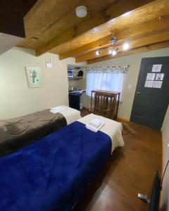 a bedroom with two beds and a table in it at Rufa’S in El Chalten