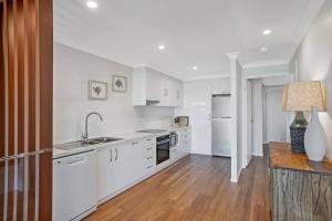a kitchen with white appliances and a wooden floor at Sunrise Reef 6 in Lennox Head