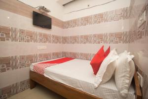 Schlafzimmer mit einem Bett und einem TV an der Wand in der Unterkunft OYO Hotel Kshounish Residency in Māldah