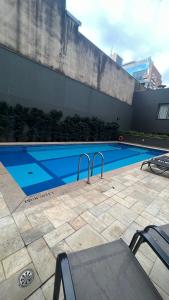a swimming pool in a yard with chairs at Studio Inside Hotel Windham in Sao Paulo