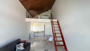 a living room with a staircase leading up to a loft at Villa Suíça, Chalé Mezanino in Tianguá