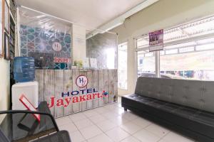 ein Hotel-Restaurant mit Straßensperre und einer Bank in einem Zimmer in der Unterkunft RedDoorz Syariah @ Jalan Jendral Sudirman Jambi in Paalmerah