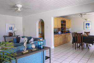 un soggiorno con un divano blu e una cucina di The Anchorage #5 a 3 bedroom Waterfront Condo in Rodney Bay condo a Gros Islet Altre 32 foto