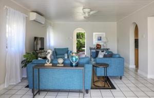a living room with a blue couch and a table at The Anchorage #5 a 3 bedroom Waterfront Condo in Rodney Bay condo in Gros Islet