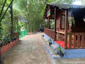 a small house with a porch and some plants at TREKKING TRAILS ECO STAY in Kalpetta