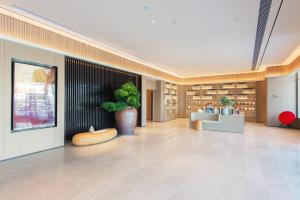 a lobby with a potted plant in a building at All Seasons Hotel - Jiaozhou Jiaodong Airport Liwang Road in Jiaoxian