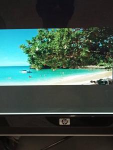 una pantalla de televisión con una foto de la playa en Villa Milly Cabrera, 