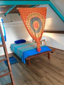 een kamer met een bed met een net erop bij L'Auberge de Tahiti Iti - Beach hostel in Afaahiti