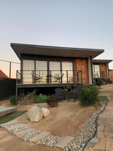 uma pequena casa com um alpendre e um pátio em Finca Cazosa em Valle de Guadalupe