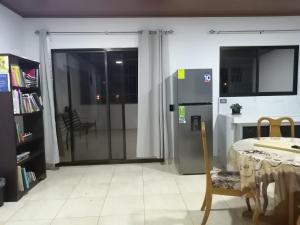 een woonkamer met een tafel en een koelkast bij Mirada al Cerro, Apartamento completo in Grecia