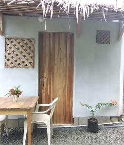 Zimmer mit einem Tisch und einer Holztür in der Unterkunft Casa Tauchin in Puerto Viejo