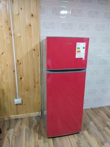 a red refrigerator in a room with a wall at Cricri in Castro