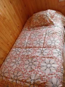 uma cama com uma colcha e almofadas vermelhas e brancas em Cricri em Castro