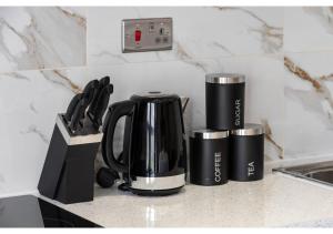a coffee pot and cups on a kitchen counter at Brand New Homey and Stylish Perfect for Travellers in London