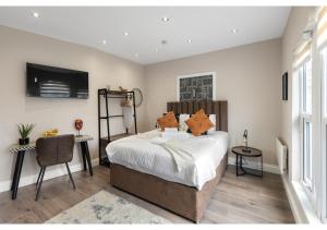 a bedroom with a large bed and a chair at Brand New Homey and Stylish Perfect for Travellers in London