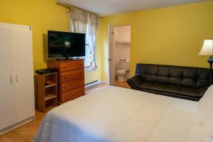 um quarto com uma cama, um sofá e uma televisão em 310 Intimité au Cœur de l'Histoire em Trois-Rivières