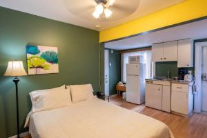 1 dormitorio con 1 cama blanca y cocina en 310 Intimité au Cœur de l'Histoire, en Trois-Rivières