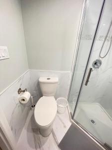 a white bathroom with a toilet and a shower at Arbutus Jasmine room in Vancouver
