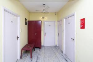 un corridoio vuoto con due porte e una panchina rossa di Kalighat a Ālīpur