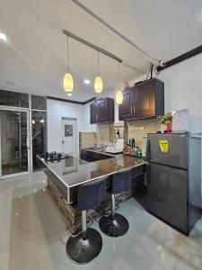 a kitchen with a counter and two bar stools at 3MC Guest House in Butuan