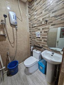 a bathroom with a shower and a toilet and a sink at 3MC Guest House in Butuan
