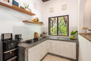 una cocina con fregadero y estufa en Twist and Shout Villa, en Seminyak